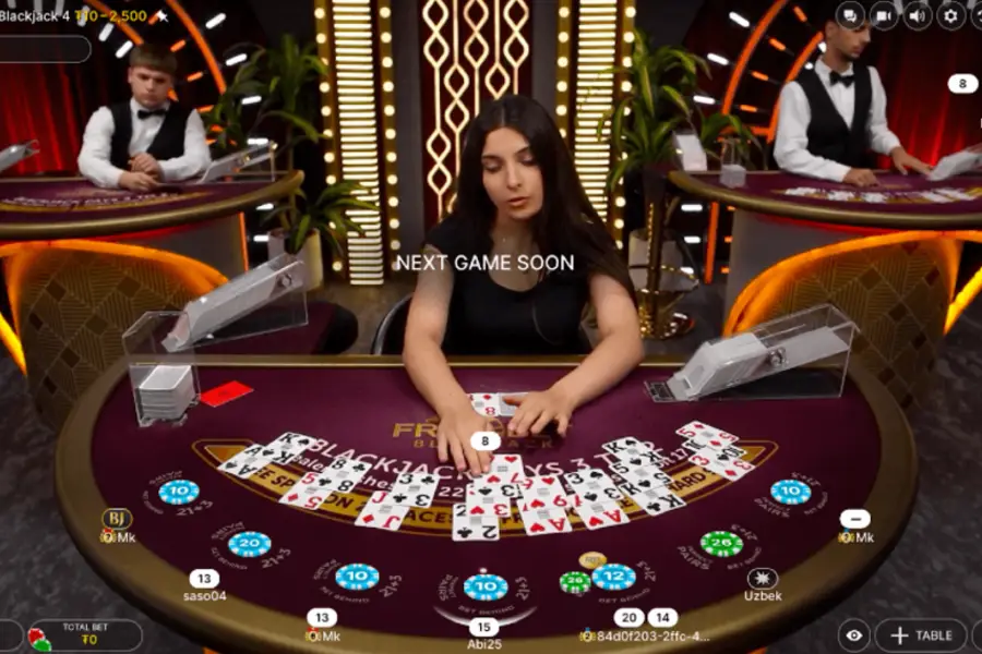 A dealer expertly handles the cards for multiple players in a live game of Blackjack.